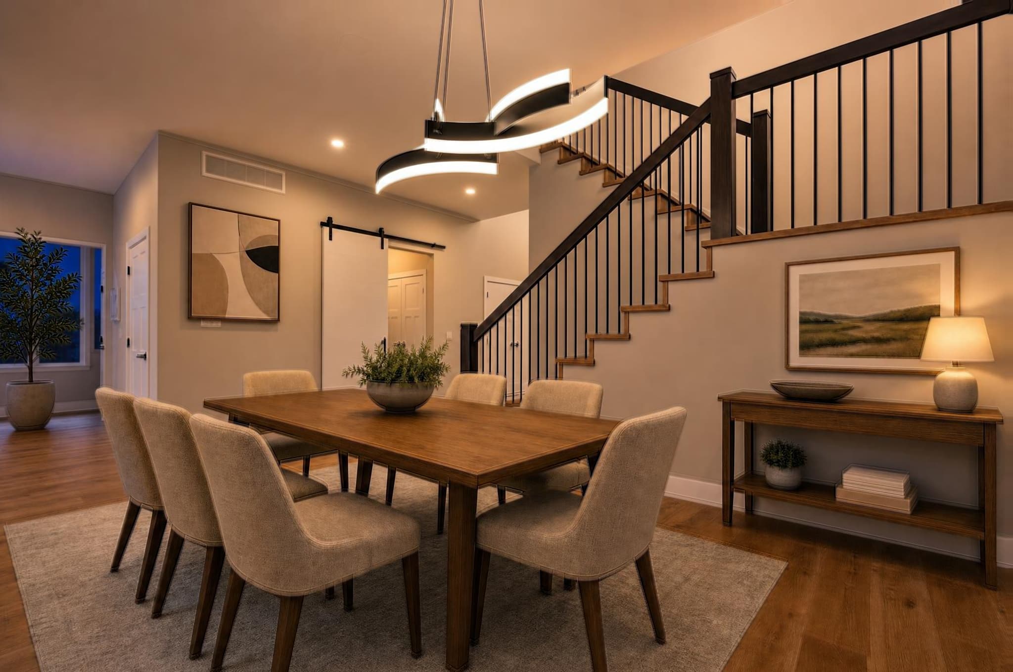 A dining room relit in Evening Glow with staircase rails and warm interior light
