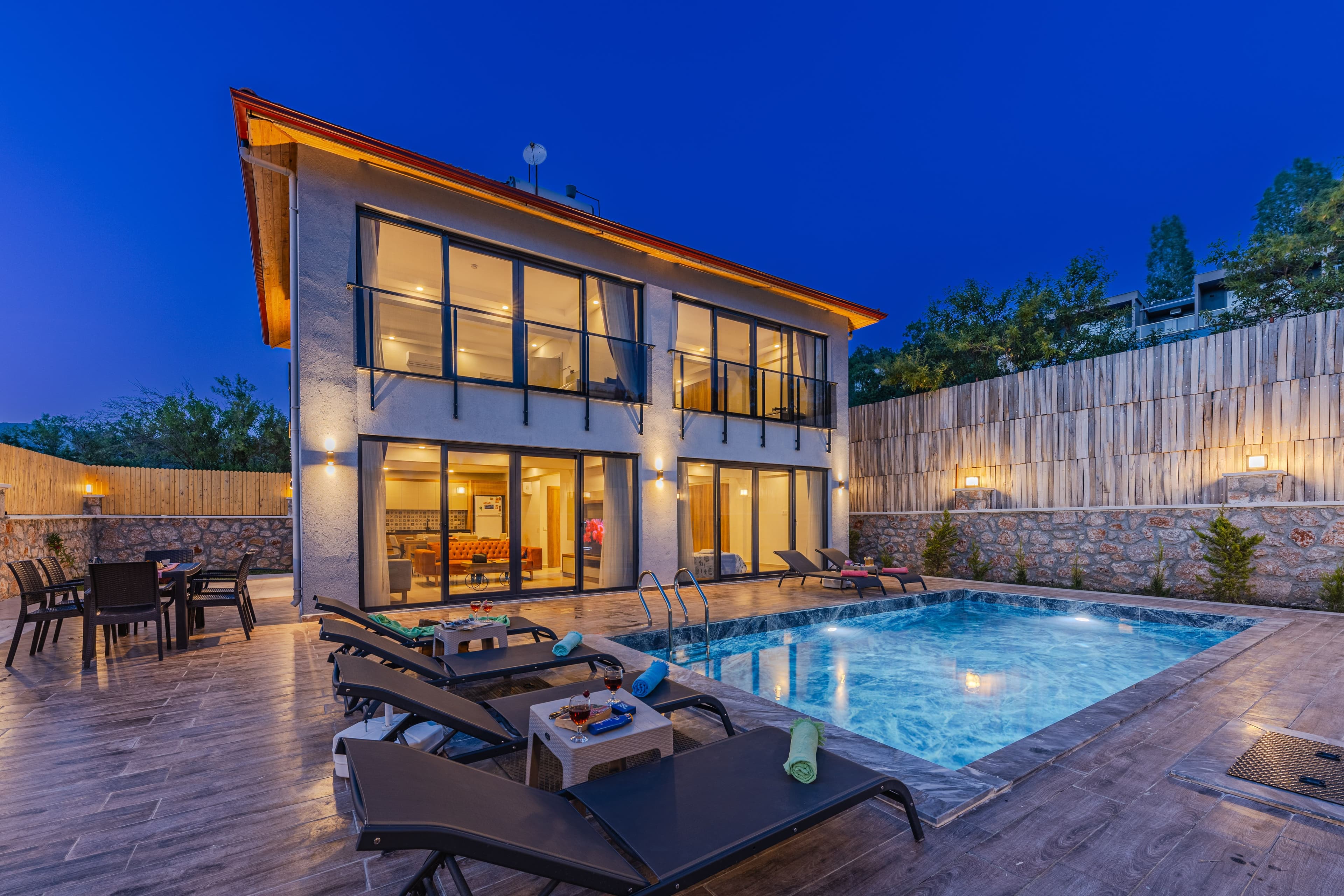 A luxury house and swimming pool photographed beneath a twilight sky