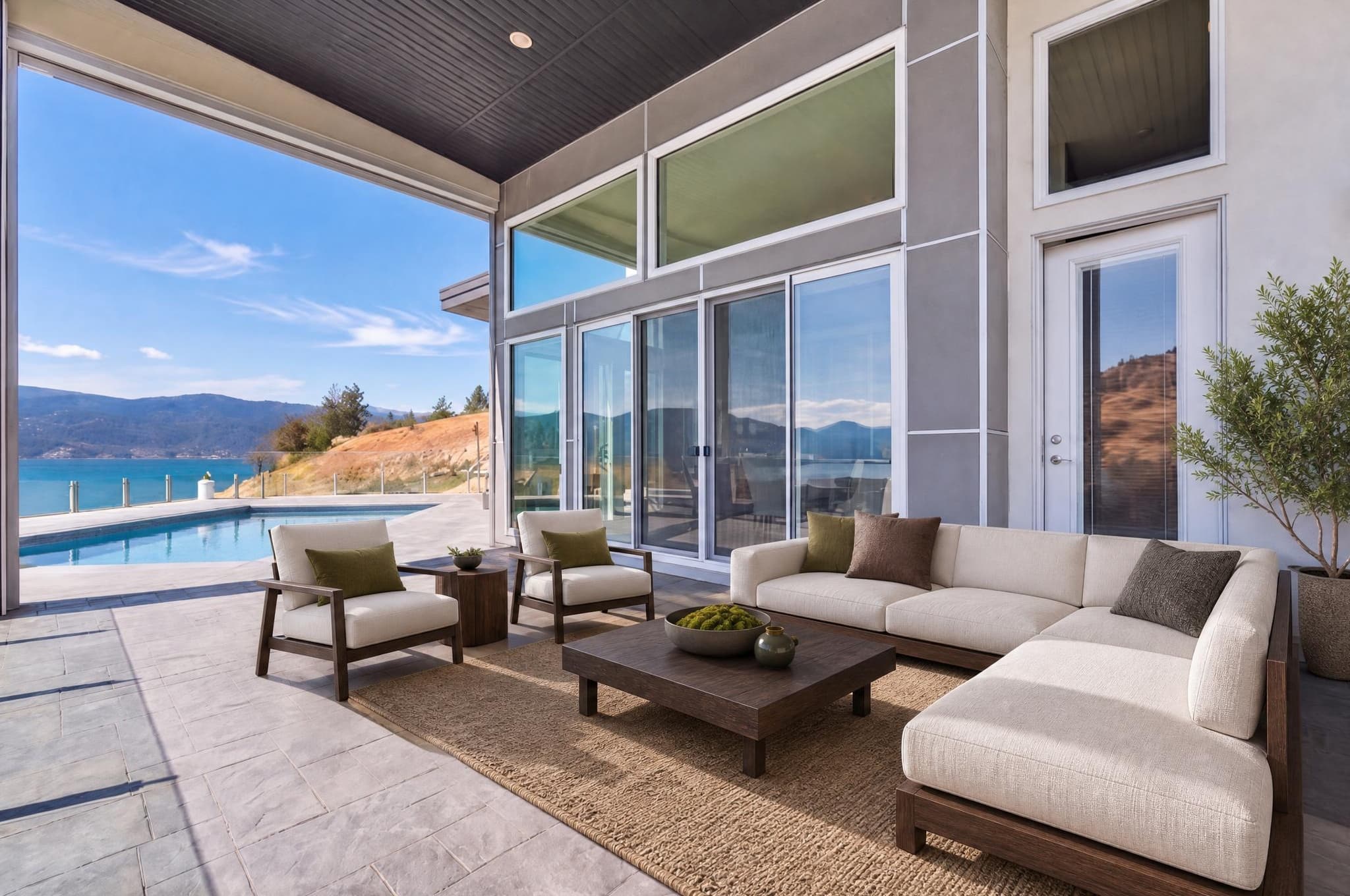 A furnished covered patio overlooking a swimming pool and lake